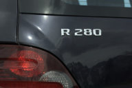 Mercedes-Benz R 280 CDI, normaler Radstand, Baureihe 251, 2007, mit geänderter Front- und Heckschürze (vorher Styling AMG, Code 772). Obsidianschwarz metallic (197), Interieur Alpakagrau, Panorama-Schiebedach (Sonderausstattung, Code 413). Sport-Paket (Code 952, ab 2007 Sportpaket EXTERIEUR, Code P96) mit wärmedämmendem Glas blau rundum, 19-Zoll-Sportfelgen im 5-Speichen-Design, Rückleuchten in Sportoptik dunkel, Chromzierteilen und Kühlergrill Sterlingsilber mit Chrom. Typenzeichen an der Heckklappe, links.