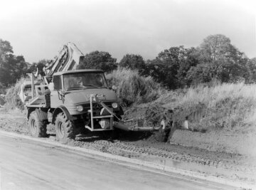 Mercedes-Benz Unimog model U 80 of model series 406 with attached Hoes feed auger moves the excavated material back into the ditch, 1970.