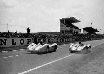 French Grand Prix, 1954: The eventual race winner Juan Manuel Fangio (start number 18) and second-placed Karl Kling (start number 20), both in the Mercedes-Benz W 196 racing car.