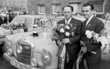 29. Rallye Monte Carlo, 18.- 24.01.1960. Siegerehrung für Walter Schock und Rolf Moll vor dem Stuttgarter Hauptbahnhof 1960. Die Rallyewagen sind gewaschen, die Fahrer mit  schicken Anzügen und mit Blumensträußen herausgeputzt.