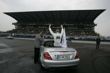 DTM 2005 (1. heat) Hockenheim, 17.04.2005. Mika Häkkinen, Sport Edition AMG-Mercedes, in a Mercedes-Benz SLK 55 AMG in front of the Mercedes grandstand.