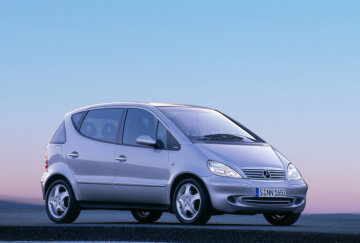 Mercedes-Benz A 190 lang, Baureihe 168, Version 2001, Polarsilber metallic (761), Stoff Schiefergrau (678). Bei der Ausstattungslinie AVANTGARDE ist der Kühlergrill in Silber lackiert. Die Seitenschutzleisten, die Türgriffe mit Chromeinlage und die Außenspiegelgehäuse sind in Wagenfarbe ausgeführt. Die Heckleuchten sind bichromatisch dunkel, die Auspuffblende besteht aus Edelstahl. Leichtmetallräder im 5-Loch-Design. Sonderausstattungen: Lamellenschiebedach (Code 417), PARKTRONIC (220).