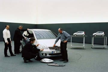 Mercedes-Benz A-Class, model series 169, 2004, design team, consultation on details using very near-series models on a 1:1 and 1:4 scale. Second from left: Jürgen Bollmann, third from left: Thomas Haase, right: Jürgen Fauss. The design of the 169 model series has taut contours and tight lines and suggests powerful forward thrust even when stationary. Right from the start of design development work, the computer played an important part as a tool. In the virtual world, various draft designs for the interior and exterior were assessed, modified, refined and later modelled.