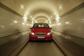 Mercedes-Benz A 180 CDI Coupé, model series 169, 2004, 4-cylinder turbodiesel engine OM 640, 1991 cc, 80 kW/109 hp. Jupiter red (589), equipment line AVANTGARDE including high-gloss back on the radiator, chrome trim, dark-tinted rear lamps, interior trim elements in matt aluminium. Special equipment: 17-inch light-alloy wheels in 7-spoke design (as in Sport Package), panoramic lamella sliding sunroof (Code 417), PARKTRONIC (Code 220). Photoshoot in St. Pauli - Elbtunnel, Hamburg/Germany.