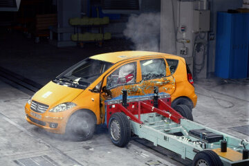 Mercedes-Benz A-Klasse, Baureihe 169, Seiten-Crashtest in der Crashhalle des Mercedes-Benz Sicherheitszentrums, Werk Sindelfingen/Deutschland, 2004. Für die neue A-Klasse hat Mercedes-Benz das intelligente Sandwich-Konzept weiterentwickelt und im Detail verbessert. Für umfassende Insassensicherheit sorgen auch adaptive Front-Airbags, die sich je nach Unfallschwere in zwei Stufen entfalten, und neu entwickelte Head-/Thorax-Bags. Sie schützen beim Seitenaufprall Kopf und Brustbereich der Frontpassagiere. Die höhere Sitzposition bewirkt ebenfalls strukturellen Schutz für die Passagiere.