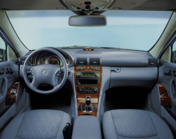 Mercedes-Benz C-Klasse Limousine, Baureihe 203, ab 2000, Interieur. Ausstattungslinie ELEGANCE mit Stoffmuster Cambridge und Holz Laurel, Lenkrad sowie Schalthebelknauf und -balg in Leder in Ausstattungsfarbe.