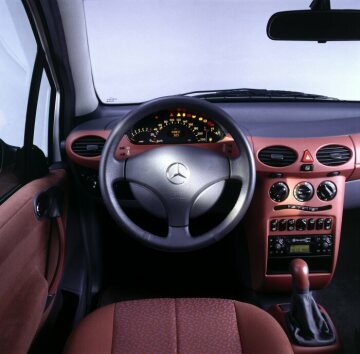 Mercedes-Benz A 140, model series 168, 1997, 4-cylinder petrol engine M 166, 1397 cc, 60 kW/82 hp, moonlight silver metallic (706), interior Ghent fabric in brick red (007). Equipment line Classic including steering wheel with plastic surround, cockpit trim panels in upholstery colour, instrument cluster with dark dial face, plastic shift lever inlay.