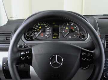 Mercedes-Benz A-Klasse, Baureihe 169, 2004, Kombiinstrument, hier in einer Limousine, mit vier übersichtlichen Rundinstrumenten, serienmäßig mit Außentemperatur- und Bremsbelagverschleißanzeige sowie Drehzahlmesser. Serienausstattung: Multifunktions-Lenkrad, Fensterheber elektrisch 2fach vorn, mit Tieflaufsteuerung (2fach elektrisch hinten mit automatischer Hoch-/Tieflaufsteuerung und Komfortschließung vorn und hinten als Lieferumfang bei ELEGANCE). Sonderausstattungen: Leder Alpakagrau (808), Ausstattungslinie ELEGANCE (955) mit Zierteilen Holz Myrte (sowie Lederlenkrad, Lederschalthebel und -handbremsgriff), PARKTRONIC (Code 220), COMAND APS mit DVD-Navigationssystem und integriertem Radio mit CD-Player, Telefontastatur und 6 Lautsprechern (527), Klimatisierungsautomatik THERMOTRONIC (581).