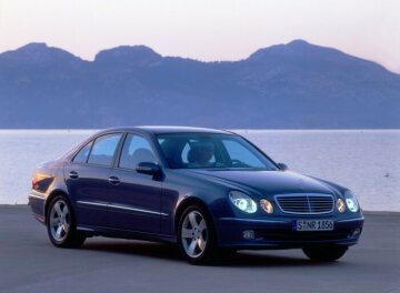 Mercedes-Benz E 500 Saloon, model series 211, 2003 version. Teallite blue metallic (353), AVANTGARDE equipment line, 5 louvres in radiator grille, bi-xenon headlamps, 5-spoke light-alloy wheels. Electric panoramic sunroof (optional extra).