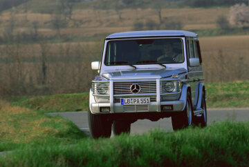 Mercedes-Benz G 55 AMG, Station lang, Geländewagen, Baureihe 463, 2000, erscheint ab 2003 als Spitzenmodell. Edelstahl-Rammschutz, Heckleuchten- und Scheinwerferschutzgitter. V8-Motor M 113 mit 5.439 cm³ und 260 kW/354 PS, Höchstgeschwindigkeit elektronisch begrenzt auf 210 km/h. Seit November 2001 ist die G-Klasse erstmals offiziell in den USA erhältlich, sie trifft auf unerwartet große Nachfrage.