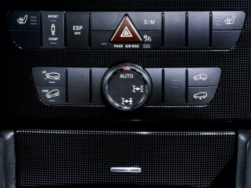 Mercedes-Benz ML 350 4MATIC, Baureihe 164, Version 2005, V6-Ottomotor M 272 KE 35, 3.498 cm³, 200 kW/272 PS, 7G-TRONIC. Studioaufnahme, Detail des Mitteldoms, Schalterleiste mit Fahrwerks- und Traktionseinstellungen der zusätzlichen Komponenten des Offroad-Pro Technikpakets für erhöhte Geländegängigkeit, sowie auch den Bedientasten für die Sitzheizung (Sonderausstattungen). Sportpaket mit Ledernachbildung ARTICO/Alcantara Schwarz (901) und Zierteilen in Aluminium Silber und Schwarz (Sonderausstattung).