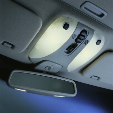 Mercedes-Benz S-Class, model series 220, 1998 version, interior. The roof console with its rounded shapes contains elements of the interior lighting and reading lights, microphones for voice control and operation of the sliding sunroof (glass version, special equipment). The standard rain sensor for the windscreen wipers is also located in the area of the inside mirror. On request, the inside mirror (together with the left-hand outside mirror) can be automatically dimmed (code 249, standard equipment on the S 430 and S 500).