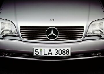 Mercedes-Benz 600 SEC (from 06.1993: S 600 Coupé), model series 140, 1992 version. Front section characterised by the SL radiator grille, coupé character without continuous B-pillars, rear lights in integrated design. V12 spark-ignition engine M 120 with 5987 cc and 290 kW/394 hp. Brilliant silver (metallic paintwork at no extra charge), grey interior (velour upholstery as standard, leather as an option at no extra charge). Headlamp wiper system with dynamic headlamp range control.