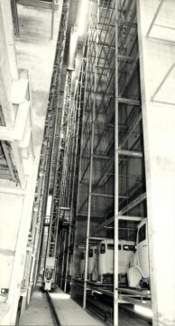 Werk Wörth, 1976. Blick in eine der vier Gassen, die das Hochregallager durchziehen. Das Regalhebezeug setzt eben ein Fahrerhaus in eines der Regale der 2. Etage selbstverständlich vollautomatisch.