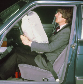 Die Mercedes-Benz S-Klasse der Modellreihe W 126 ist 1981 das erste Automobil mit Fahrer-Airbag und Gurtstraffern für Fahrer und Beifahrer. Mercedes-Benz sieht den Airbag immer als Ergänzung zum Sicherheitsgurt vor, wie dieses Foto unter Beweis stellt.