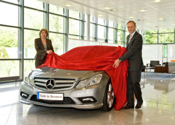 First Mercedes-Benz E-Class Coupé following the market launch is delivered at the customer centre in Bremen: Peter Schabert, plant manager Mercedes-Benz plant Bremen, and Doris Heitkamp-Koenig, head of the Mercedes-Benz customer center in Bremen, are presenting the first E-Class Coupé to its new owner.