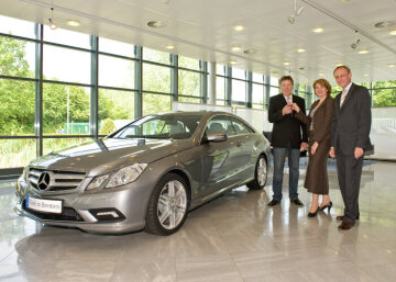 Siegfried Möller (left) picks up the key for his new Mercedes-Benz E-Class Coupé from Peter Schabert, manager of the Mercedes-Benz plant in Bremen, and Doris Heitkamp-Koenig, head of the Mercedes-Benz customer center in Bremen.