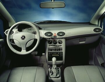 Mercedes-Benz A-Class, model series 168, 1997, interior, equipment line Elegance (steering wheel with leather rim and dark dial face), leather upholstery in slate grey (208) as special equipment. The design of the instrument panel with the new three-spoke steering wheel (diameter 370 millimetres) incorporated the latest ergonomic findings. The controls were easily accessible to the driver or front passenger. The needles of the speedometer, rev counter and fuel gauge only became visible when the ignition was switched on, and were transparent. The information on the centrally positioned multi-information display was therefore visible at all times. Special equipment shown here: Air conditioner with activated charcoal filter (Code 580).