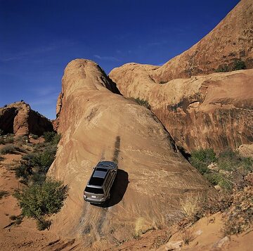 Mercedes-Benz GL 450 4MATIC, model series 164, 2006 USA version, genre photo climbing a rock formation in the USA. Cubanite silver (pewter) metallic (also available in the USA on special request, non-metallic paint finish as standard). In the USA as standard with non-opening rear panoramic roof above the 3rd seat row, including roller sunblind, and electric sliding/tilting glass sunroof (the latter as special equipment in Germany). Rear side windows and rear window with dark-tinted glass (privacy glass, standard equipment in the USA, special equipment in Germany). 19-inch 5-twin-spoke light-alloy wheels (standard equipment in Germany for GL 420 CDI 4MATIC, GL 450 4MATIC and GL 500 4MATIC).