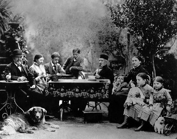 Daimler family at 1885 on the terrace of their villa in Cannstatt. 
From the left: Gottlieb Daimler, his sister-in-law Marie Kurz, sons Paul and Adolf, Daimler's father-in-law Friedrich Kurz - a pharmacist, Daimler's youngest son Wilhelm, his first wife Emma - named Kurz by birth,  the oldest daughter Emma and finally the second daughter Martha; and not forgetting the dog "Bello".