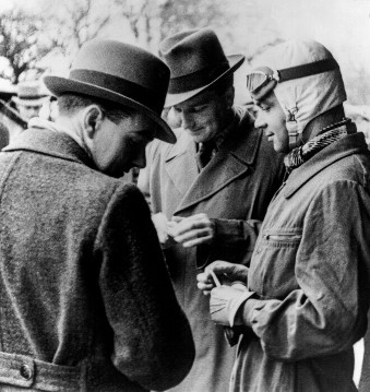 Hans-Joachim Bernet, Manfred von Brauchitsch und Rudolf Caracciola im Gespräch während der Rekordfahrten auf der Avus in Berlin, 10.12.1934.