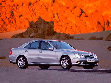 Mercedes-Benz E 55 AMG Limousine, Baureihe 211, Version 2003. V8-Kompressormotor M 113 E 55 ML, 5.439 cm³, 350 kW/476 PS, 5-Gang-Automatikgetriebe mit AMG SPEEDSHIFT, Brillantsilber Metallic. AMG Styling vorn/hinten und seitlich, 18-Zoll AMG Leichtmetallräder im 5-Doppelspeichen-Design, lackiert in Sterlingsilber, AMG Sportfahrwerk, AMG Hochleistungs-Bremsanlage und -Abgasanlage mit 2 verchromten Doppelendrohren im AMG Design. Schriftzug "V8 KOMPRESSOR" beidseitig vorne am Wagen.