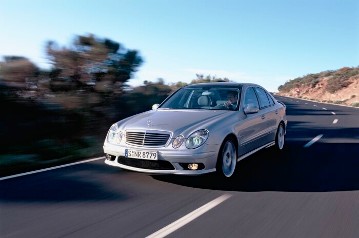 Mercedes-Benz E 55 AMG Limousine, Baureihe 211, Version 2003. V8-Kompressormotor M 113 E 55 ML, 5.439 cm³, 350 kW/476 PS, 5-Gang-Automatikgetriebe mit AMG SPEEDSHIFT, Brillantsilber Metallic. AMG Styling vorn/hinten und seitlich, 18-Zoll AMG Leichtmetallräder im 5-Doppelspeichen-Design, lackiert in Sterlingsilber, AMG Sportfahrwerk, AMG Hochleistungs-Bremsanlage und -Abgasanlage mit 2 verchromten Doppelendrohren im AMG Design. Schriftzug "V8 KOMPRESSOR" beidseitig vorne am Wagen.