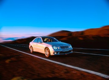 Mercedes-Benz E 55 AMG Saloon, model series 211, 2003 version. Supercharged V8 engine M 113 E 55 ML, 5439 cc, 350 kW/476 hp, 5-speed automatic transmission with AMG SPEEDSHIFT, brilliant silver metallic. AMG bodystyling front/rear and side, 18-inch AMG 5-twin-spoke light-alloy wheels painted in sterling silver, AMG sport suspension, AMG high-performance braking system and exhaust system with 2 chrome-plated twin tailpipes in AMG design. "V8 KOMPRESSOR" lettering on both front wings.