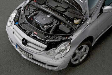 Mercedes-Benz R 500 4MATIC, model series 251, 2005, iridium silver metallic (775). View of the engine compartment: V8 petrol engine M 113, 4966 cc, 225 kW/306 hp. Special equipment: Sport Package (Code 952) with 19-inch sport wheels in 5-spoke design and radiator shell in sterling silver with chrome, PARKTRONIC (Code 220).