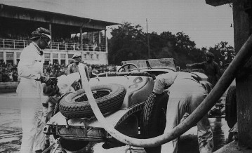 Großer Preis von Deutschland auf dem Nürburgring, 19.07.1931. Der Sieger Rudolf Caracciola (Startnummer 8) beim Auftanken am Mercedes-Benz SSKL, (rechts) Beifahrer Wilhelm Sebastian beim Reifenwechsel.