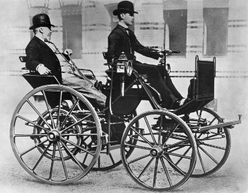 Gottlieb Daimler enjoying a ride in the back seat of his “Motor Carriage”, driven by his son Adolf.