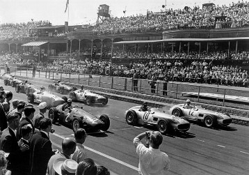 Start zum Großen Preis von England in Aintree am 16. Juli 1955. Dieses Rennen endete mit dem größten Triumph der Mercedes-Renngeschichte. Vier Mercedes-Benz W 196 R Monoposto waren am Start und vier W 196 R liefen auf den ersten vier Plätzen ein: 1. Stirling Moss (Startnummer 12), 2. Platz Juan Manuel Fangio (Startnummer 10), 3. Karl Kling (Startnummer 14), 4. Piero Taruffi (Startnummer 50).  Links im Bild mit der Startnummer 2: Jean Behra mit Maserati 250 F.