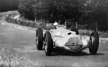 Rudolf Uhlenhaut am Steuer fährt hier einen im Gewicht verminderten Mercedes-Benz 3-l-Formel-Rennwagen W 154 auf dem Nürburgring vor dem Großen Preis von Deutschland 1937 zur Probe.