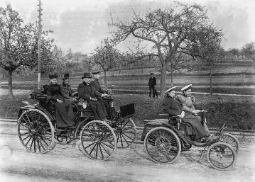 Excursion in 1895 (from Weinheim to Schrießheim along the Bergstraße). On the move in the small Benz "Velo" (right) - Benz's daughters Klara (at the wheel) and Thilde. At the wheel of the Benz Patent Motor Car "Phaeton" is Benz's son Richard. At the time he was doing military service, hence the uniform. The other passengers are relatives of the Benz family.