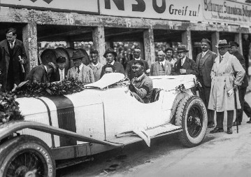 Otto Merz, nach dem Gewinn des Großen Preis vin Deutschland am 17. Juli 1927 auf dem Nürburgring mit dem Mercedes-Benz S. Im Hintergrund stehen Dr. Ferdinad Porsche (4. v. lks) und Alfred Neubauer (6.v.lks)
