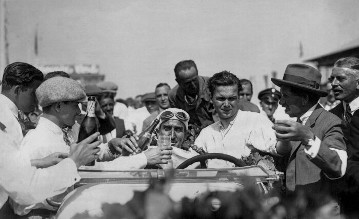 Großer Preis von Deutschland, 1928
Dreifachsieg auf dem Nürburgring: Das Fahrerteam Rudolf Caracciola / Christian Werner gewinnt auf einem Mercedes-Benz Typ SS. Direktor Ferdinand Porsche (rechts mit Hut).