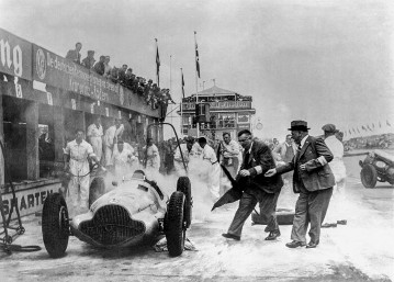 Großer Preis von Deutschland, 24. Juli 1938. Zwischenfall an den Mercedes-Benz Boxen. Manfred von Brauchitsch mußte seine Siegeshoffnungen bei diesem Rennen begraben, als sein Mercedes-Benz W 154 Feuer fing. Beim Tanken war Treibstoff übergelaufen, der sich an den Auspuffgasen entzündete. Rennleiter Alfred Neubauer (rechts) am Rennwagen.