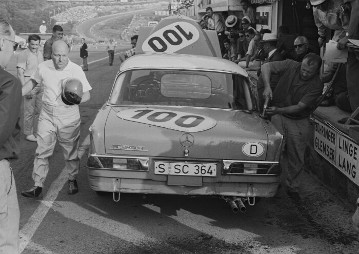 Francorchamps 24 hours race on July 25- 26, 1964. Eugen Böhringer completed the fastest race lap in a Mercedes-Benz 300 SE (start number 100) at 177.296 km/h. The photo shows drivers swapping over in front of the Mercedes-Benz pits.