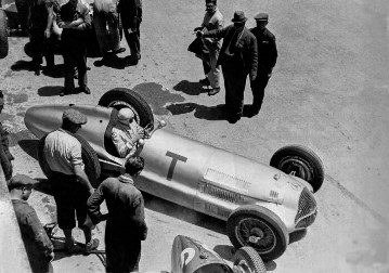 Großer Preis von Tripolis, Mellaha, 15.05.1938. Trainingsvorbereitungen an der Box. Rennfahrer Hermann Lang auf Mercedes-Benz Rennwagen W 154 mit der Startnummer T. Rennleiter Alfred Neubauer und Oberingenieur Rudolf Uhlenhaut am Rennwagen.