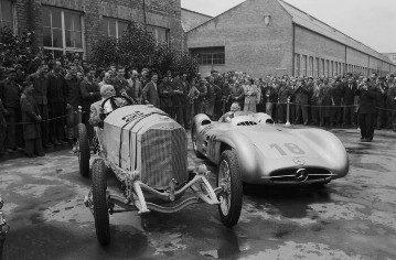 Anlässlich zum Großen Preis von Frankreich in Reims, 1954. Im Werk Untertürkheim vereint Rennmannschaft, Werksführung, Ehrengäste und Belegschaft. 40-jähriges Jubiläum zwischen dem Mercedes 115 PS Grand-Prix-Rennwagen von 1914 mit der Startnummer 28 - Max Sailer und dem Mercedes-Benz W 196 R Stromlinie mit der Startnummer 18 - Karl Kling.