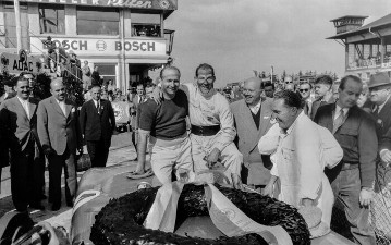 XVIII. Internationales ADAC Eifelrennen auf dem Nürburgring, 29. Mai 1955
Siegerehrung mit Juan Manuel Fangio und dem zweiten Stirling Moss, rechts daneben der ADAC-Sport-Präsident Jules Köther.