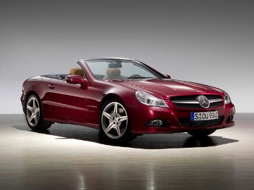 Mercedes-Benz SL 500, Baureihe 230, Thulitrot Metallic, Version 2008, mit einer Lamelle im Kühlergrill und neu gestaltetem Vorderwagen. Powerdomes auf der Motorhaube und breite Bi-Xenon-Scheinwerfer sind eindrucksvolle Merkmale der Frontansicht.