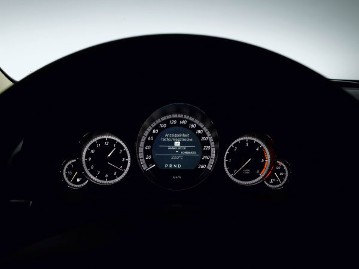 Mercedes-Benz E-Class Coupé, model series 207, 2009 version, interior. Instrument cluster in tube look with 5 analogue round instruments including rev counter and analogue clock (standard equipment). Adjustability of the display by kilometres or miles via the multifunction steering wheel.