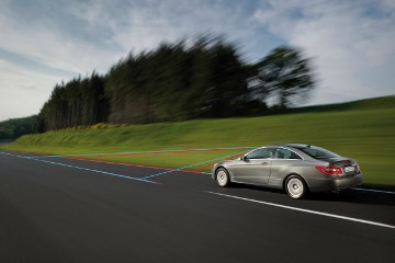 Mercedes-Benz E-Klasse Coupé, Baureihe 207, Version 2009. Kamera- und Sensortechnik an der Innenseite der Frontscheibe beobachtet das Verkehrsgeschehen und verarbeitet Information für die Steuerung der Assistenzsysteme (beispielsweise Geschwindigkeitslimit-Assistent, Sonderausstattung) und Lichtfunktionen.